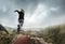 Young woman running and jumping near mountains and lake