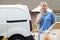 Young Woman Running Mobile Cleaning Business With Van Using Mobile Phone