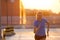 Young woman running on parking level in the city at sunset