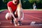 young woman on running track lacing her shoes