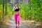 Young Woman Running on the Trail in the Beautiful Wild Forest. Active Lifestyle Concept. Space for Text.