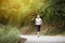 Young Woman Running In Wooded Forest Area