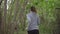 Young woman running through the woods, looking back