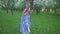 Young woman runs in an apple orchard in the spring flowers white. Portrait of a beautiful girl in the evening fruit