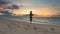 Young woman runs off ocean coast sunset background