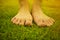 Young woman`s barefoot walking on the fresh, green grass in sunny summer in the morning. Restful moment. Healthy lifestyle. Brigh