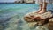 A Young Woman\\\'s Feet Gracefully Resting on a Stone Beach Amidst Turquoise Waters. Generative AI