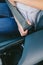 Young woman`s hand putting on seatbelt