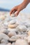 A young woman\'s hand stacks several rounded stones