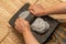 Young woman`s hands, grinding dough in the metate for the elaboration of blue tortillas, which is a typical Mexican food