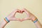 Young woman`s hands with LGBT colorful rainbow flag wristbands shaped as heart