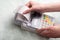 A young woman`s hands tearing a check from a cash register after purchasing a product, entering a discount on a market