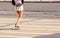 Young woman`s legs crossing an urban street