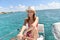 Young woman at sailboat wheel in caribbean sea