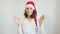 Young woman in Santa Claus hat dancing and having fun. Close up of female in Christmas hat and dancing in confetti