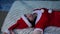 Young woman in Santa costume lying on bed. Charming female resting and celebrating Christmas at home. Concept of holidays and good