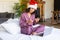 Young woman in Santa hat and pyjama. New normal, quarantine, talking with friends on video call. Celebrating Christmas -