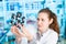 Young woman scientist working at the laboratory. Model of molecule on a