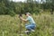 Young woman scientist zoologist sets camera trap for observing wild animals in forest to collect scientific data Environmental