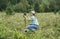 Young woman scientist zoologist sets camera trap for observing wild animals in forest to collect scientific data Environmental