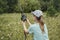 Young woman scientist zoologist sets camera trap for observing wild animals in forest to collect scientific data Environmental