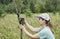 Young woman scientist zoologist sets camera trap for observing wild animals in forest to collect scientific data Environmental