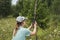 Young woman scientist zoologist sets camera trap for observing wild animals in forest to collect scientific data Environmental