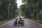 Young woman on the scooter on the road among the trees. Bali island.