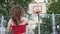 Young woman scores a goal into the basketball hoop. The athlete hits the ball into a basketball basket, slow motion