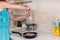 Young Woman Seasoning Meat in Frying Pan with Salt