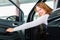 Young woman in seat of auto in car dealership