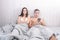 A young woman is seeking attention from men in bed, that lies and enthusiastically looking at the smartphone.