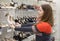 Young woman selecting new shoes in store, holding hand barefoot slippers