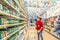 a young woman seller works in a large supermarket with a medical mask during an epidemic