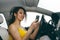 Young Woman Sending Messages while Driving.Young woman looking to her smartphone while driving car