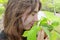 Young woman sensing spring in park by closed eyes