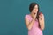 Young woman with sensitive teeth and apple on color background