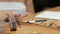 Young woman sharpens pencil and draws sitting at table indoors.