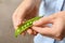 Young woman shelling green peas, closeup