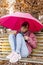 Young woman sheltering from the autumn rain