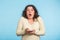 Young woman with shocked, amazed expression on blue background