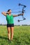 Young woman shooting arrow of compound bow