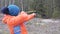 Young woman shoots a slingshot in nature