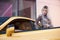 Young woman with shopping bag near the yellow super car, outdoors