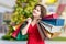 Young woman is shopping gifts for Christmas in shop and carrying many bags