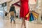 Young woman is shopping in mall and holds many colorful bags