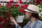 Young woman shopping in an outdoors fresh urban flowers market, buying and picking from a large variety of colorful floral