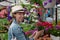 Young woman shopping in an outdoors fresh urban flowers market, buying and picking from a large variety of colorful floral