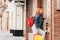 Young woman shopping in the summer sales, looking at a shop window with many colorful bags. Concept of shopaholic and lifestyle