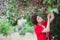 Young woman with short hair-cut standing near cherry tree